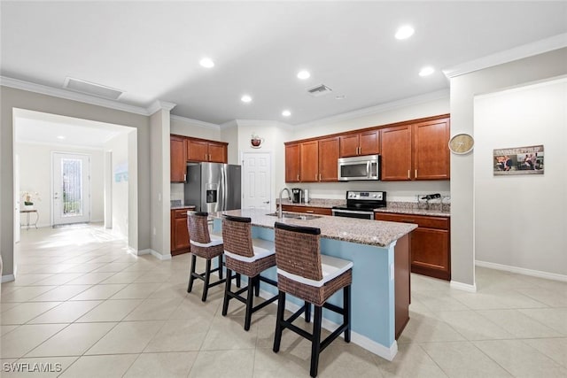 kitchen featuring a breakfast bar, stainless steel appliances, a sink, and light tile patterned flooring