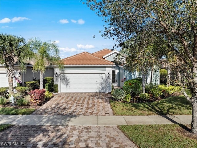 15056 Lure Trl, Bonita Springs, FL 34135 - view of front of house featuring stucco siding, an attached garage, driveway, and a tiled roof