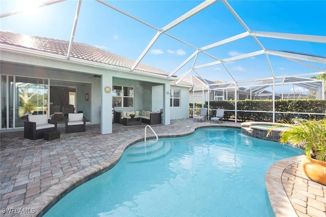 view of pool featuring a ceiling fan, a patio, glass enclosure, a pool with connected hot tub, and outdoor lounge area