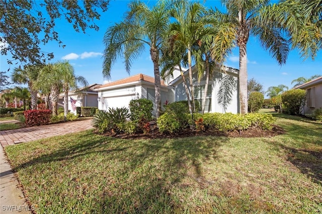 view of front of property with a garage, a front yard, and decorative driveway