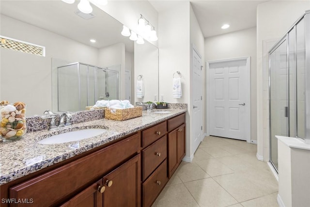 full bathroom with double vanity, a stall shower, and a sink