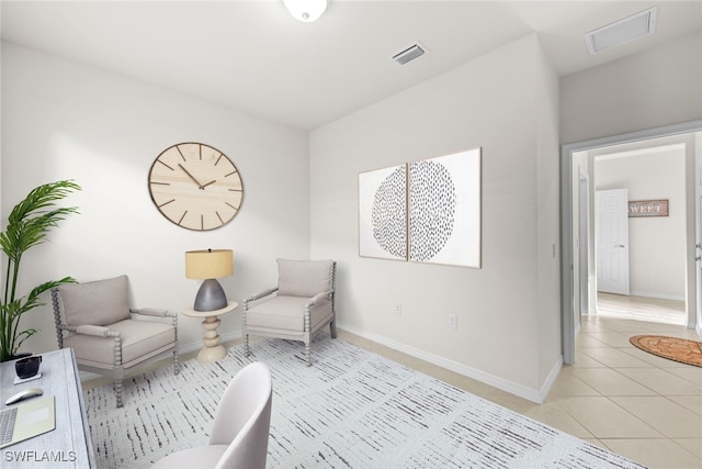 sitting room featuring light tile patterned flooring, visible vents, and baseboards