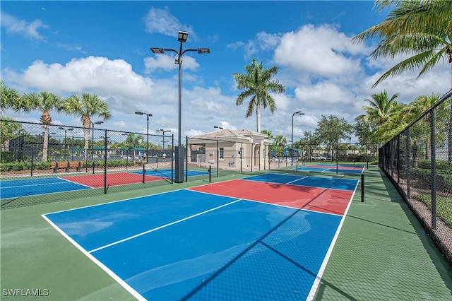 view of sport court featuring a tennis court and fence