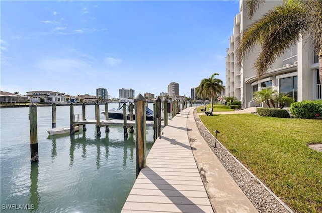 view of dock with a water view and a lawn