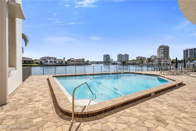 view of pool featuring a water view and a patio