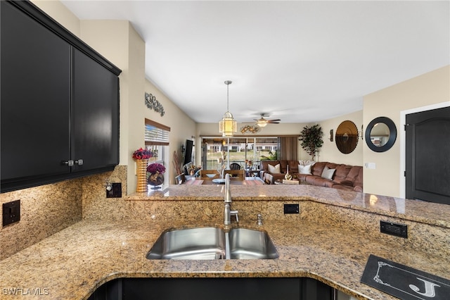 kitchen with sink, ceiling fan, backsplash, decorative light fixtures, and kitchen peninsula