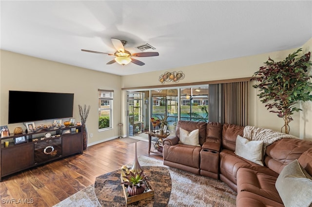 living room with dark hardwood / wood-style floors and ceiling fan