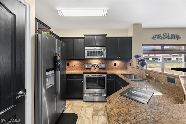 kitchen featuring tasteful backsplash, sink, stone countertops, and appliances with stainless steel finishes