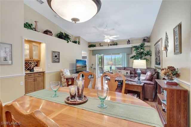 dining space with ceiling fan and vaulted ceiling