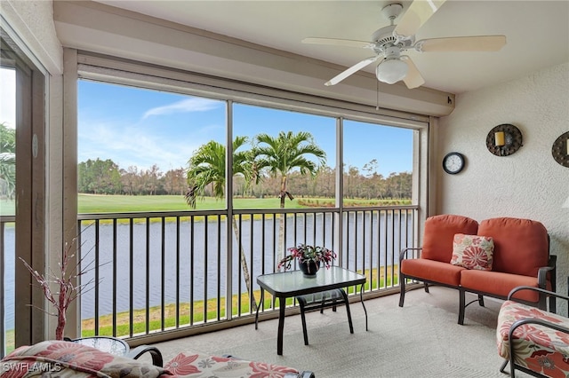 sunroom with a water view and ceiling fan