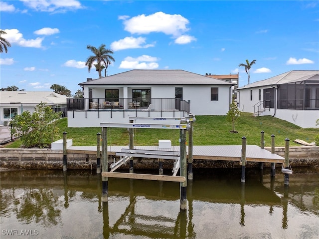 rear view of property featuring a lawn and a water view