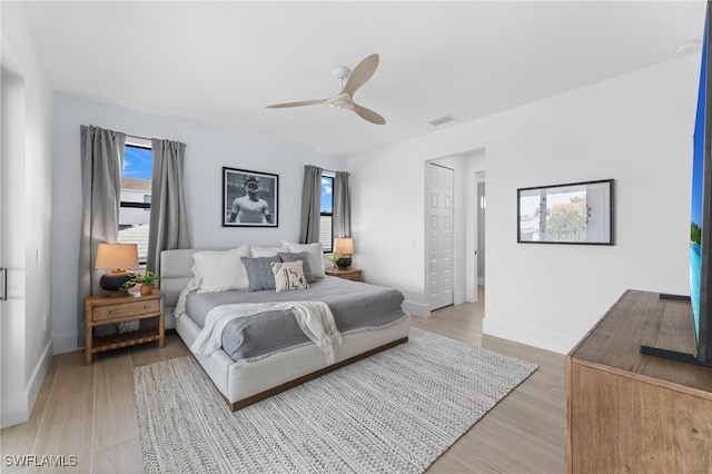 bedroom with light hardwood / wood-style floors and ceiling fan