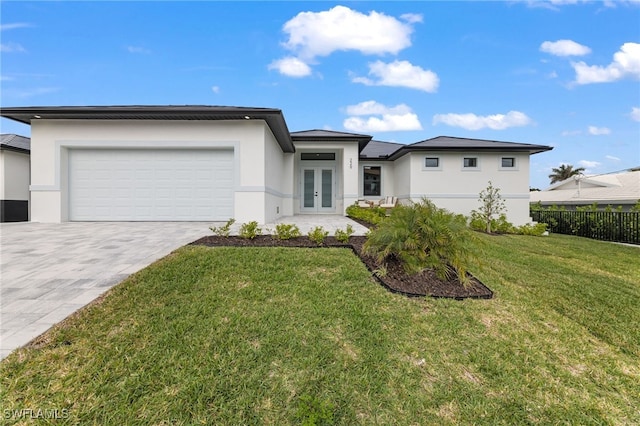 view of front of house with french doors, a garage, and a front lawn