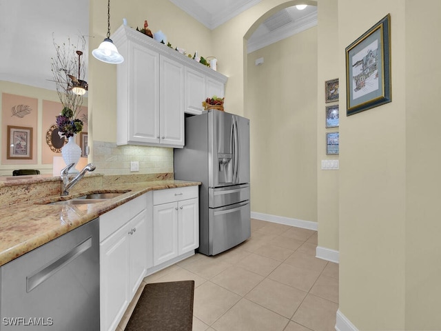 kitchen featuring sink, hanging light fixtures, stainless steel appliances, white cabinets, and decorative backsplash