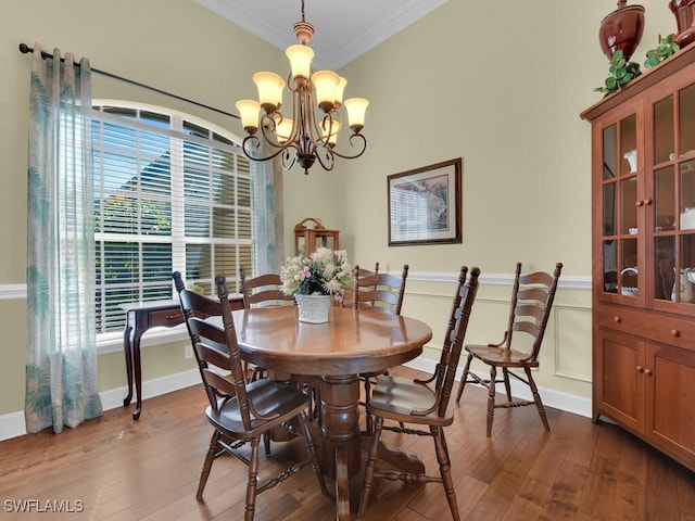 dining area featuring an inviting chandelier, wood-type flooring, and ornamental molding