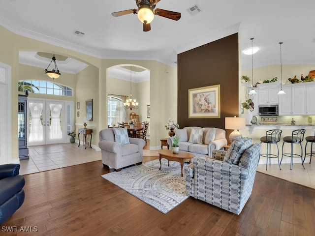 living room with french doors, ornamental molding, dark hardwood / wood-style floors, and high vaulted ceiling