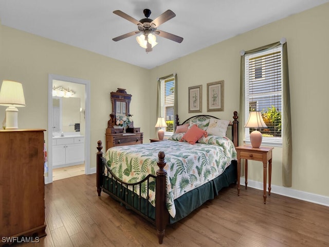 bedroom with wood-type flooring, ceiling fan, and ensuite bath