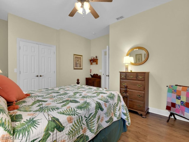 bedroom with ceiling fan, light hardwood / wood-style floors, and a closet