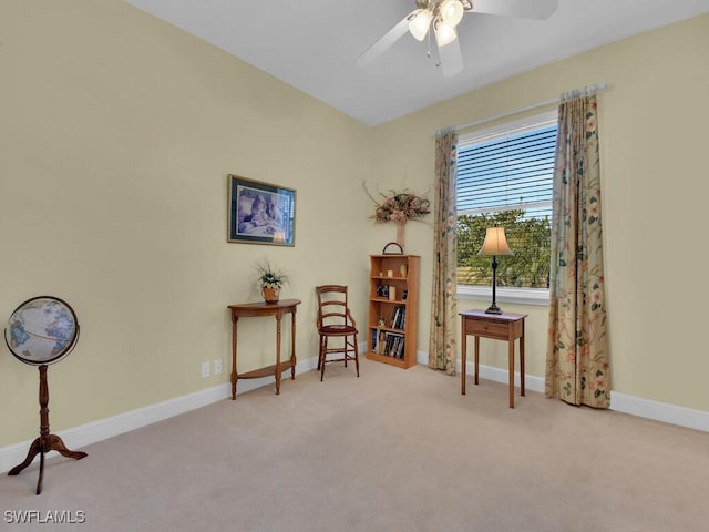 living area featuring light colored carpet and ceiling fan