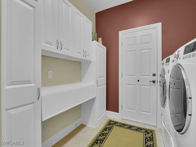 laundry area featuring cabinets, washing machine and clothes dryer, and light tile patterned floors