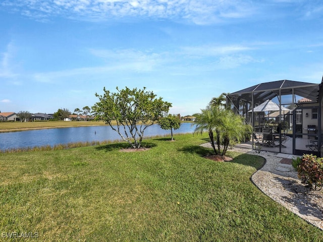 view of yard with a patio, a water view, and glass enclosure