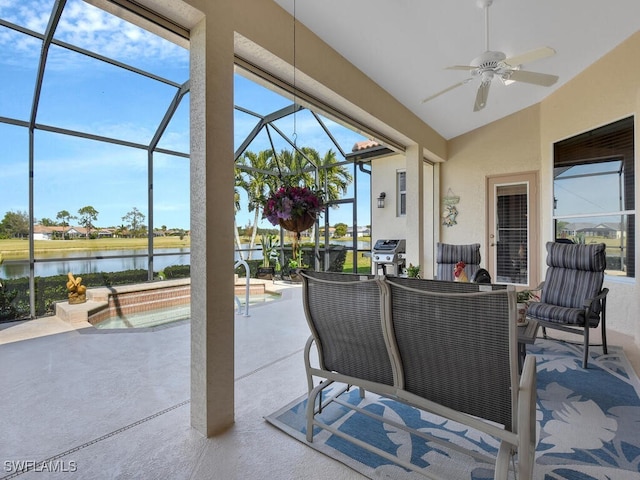 view of patio with ceiling fan, a water view, and glass enclosure