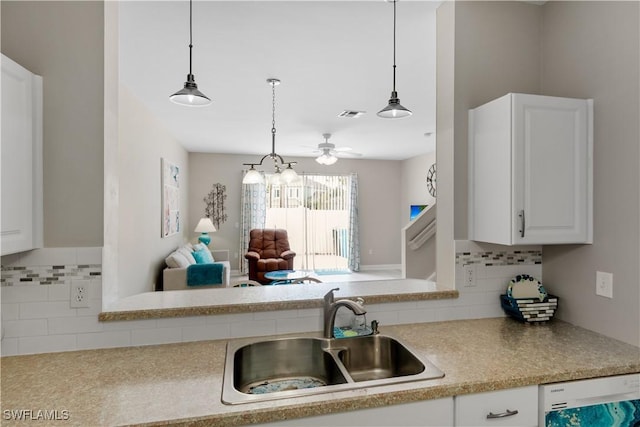 kitchen featuring sink, pendant lighting, white cabinets, and backsplash