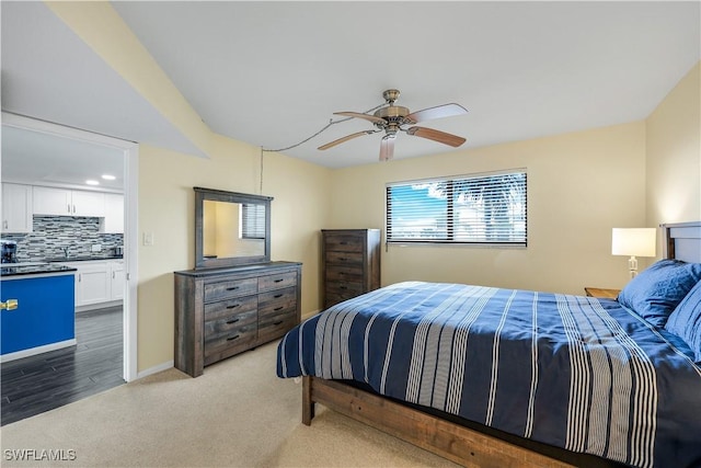 carpeted bedroom with sink and ceiling fan