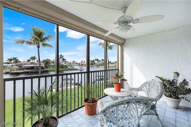 sunroom / solarium featuring a water view and ceiling fan