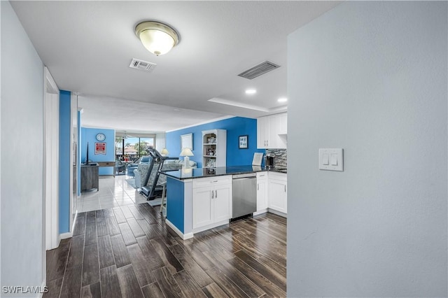 kitchen featuring decorative backsplash, kitchen peninsula, dishwasher, and white cabinets