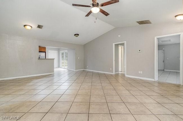 unfurnished room with ceiling fan, vaulted ceiling, and light tile patterned flooring