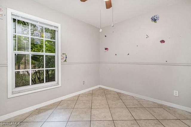 tiled empty room featuring ceiling fan