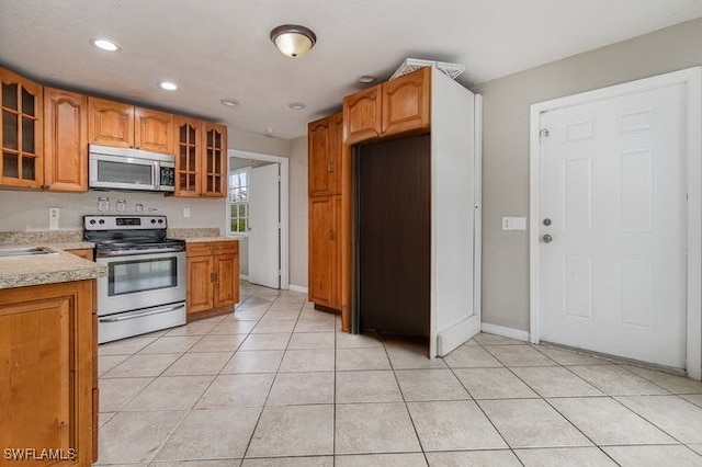 kitchen featuring sink, light tile patterned floors, and appliances with stainless steel finishes