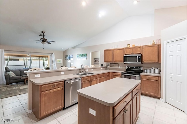 kitchen featuring stainless steel appliances, vaulted ceiling, a kitchen island, and sink