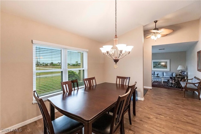 dining area featuring hardwood / wood-style flooring and ceiling fan with notable chandelier