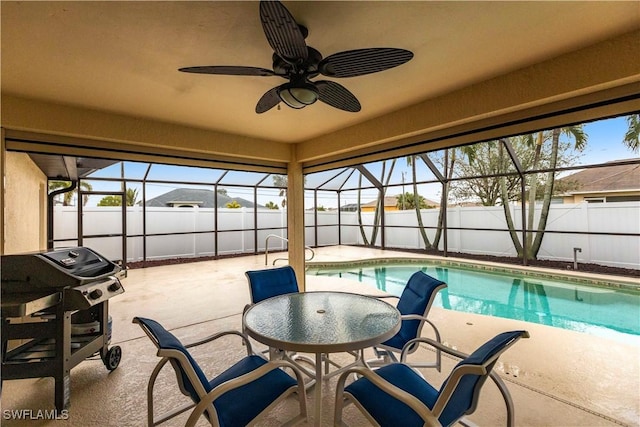 view of swimming pool featuring area for grilling, a patio, ceiling fan, and glass enclosure