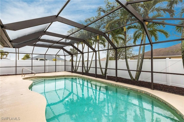 view of swimming pool featuring a patio area and glass enclosure