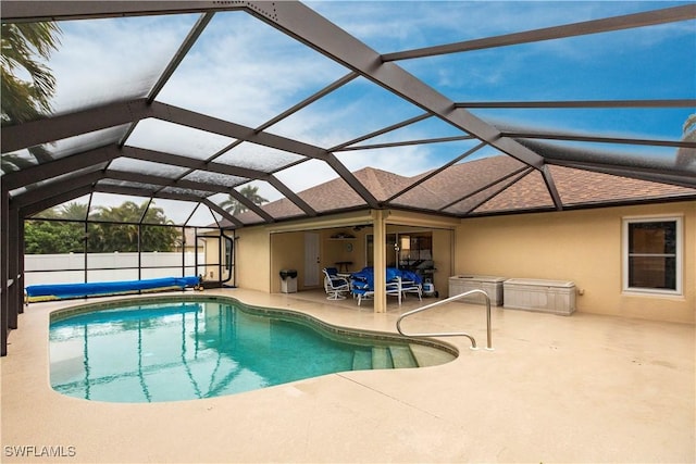 view of swimming pool featuring a patio and glass enclosure