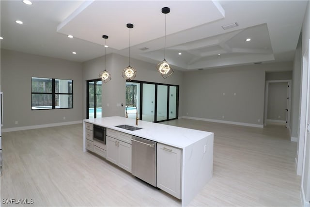 kitchen featuring sink, dishwasher, hanging light fixtures, black microwave, and white cabinets