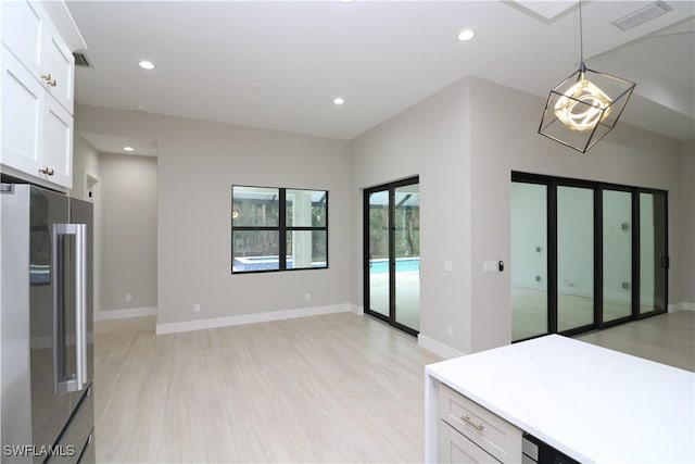 kitchen featuring white cabinetry, high end refrigerator, light hardwood / wood-style flooring, and pendant lighting