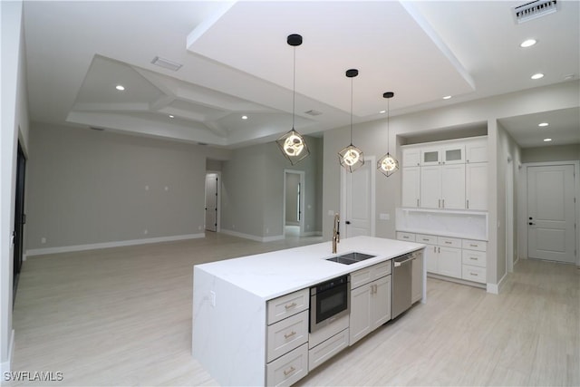 kitchen featuring pendant lighting, sink, white cabinets, a kitchen island with sink, and stainless steel appliances