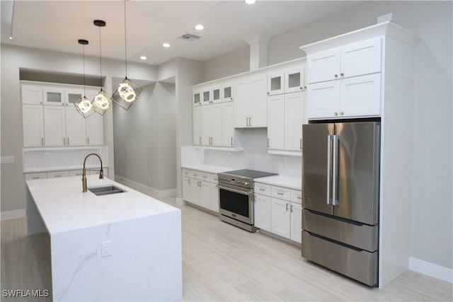 kitchen featuring appliances with stainless steel finishes, sink, white cabinets, decorative backsplash, and hanging light fixtures