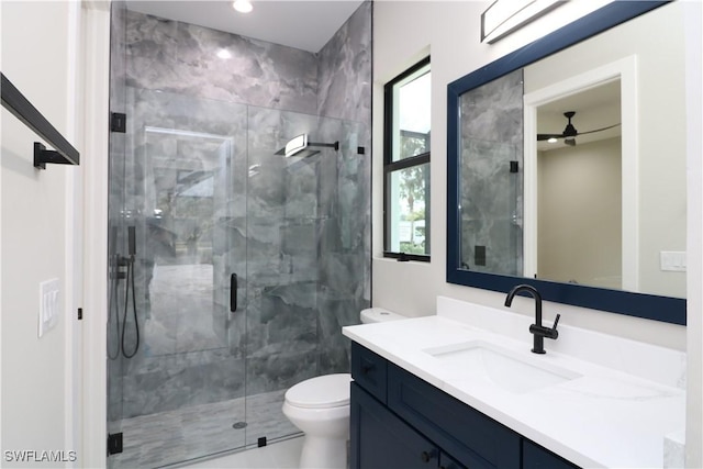 bathroom featuring vanity, a shower with door, and toilet