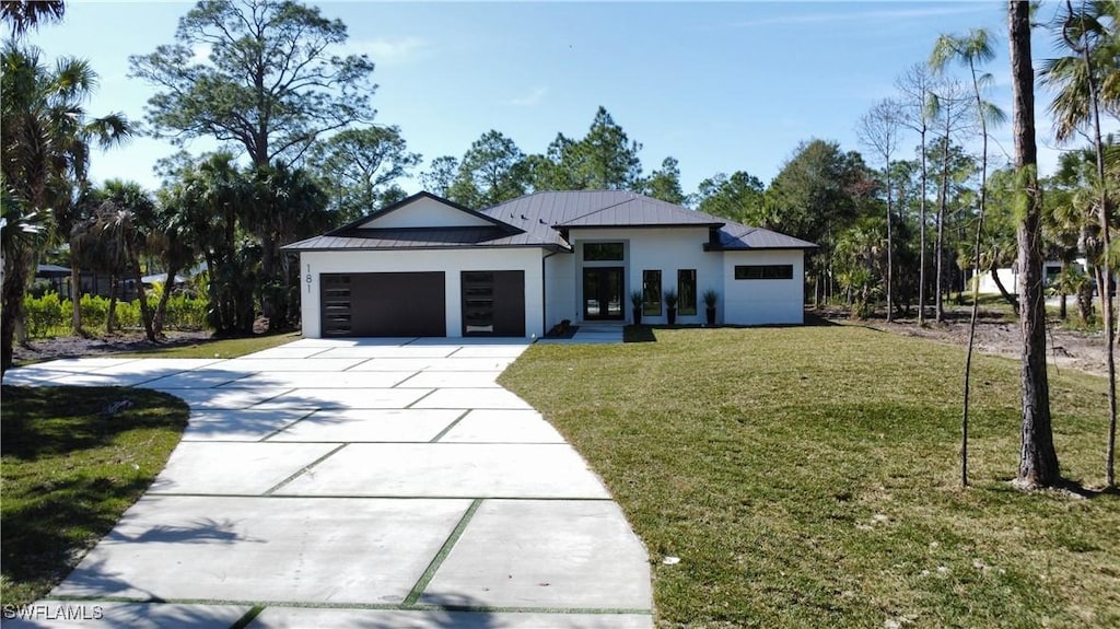 181 9th St SW, Naples, FL 34117 - view of front of house featuring a garage and a front yard