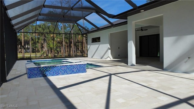 view of swimming pool with an in ground hot tub, ceiling fan, glass enclosure, and a patio