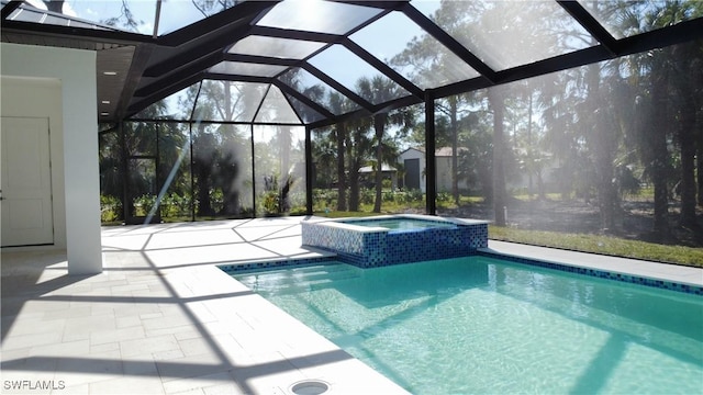 view of pool with an in ground hot tub, a patio, and glass enclosure