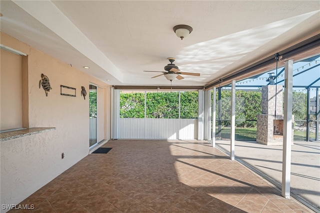 unfurnished sunroom with ceiling fan