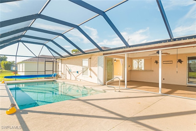 view of pool with ceiling fan, a patio area, and glass enclosure