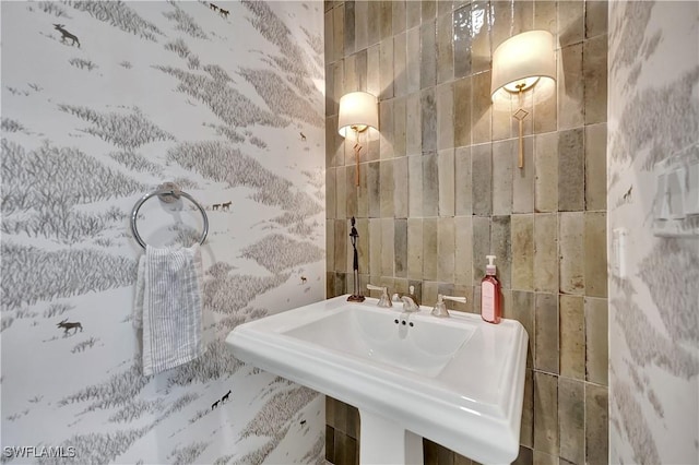 bathroom featuring sink and tile walls