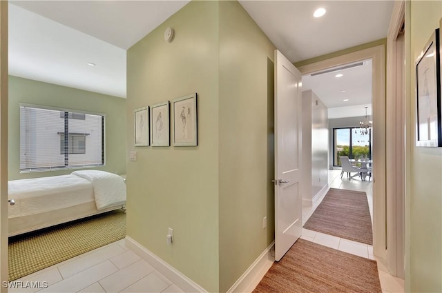 hall featuring a chandelier and light tile patterned flooring